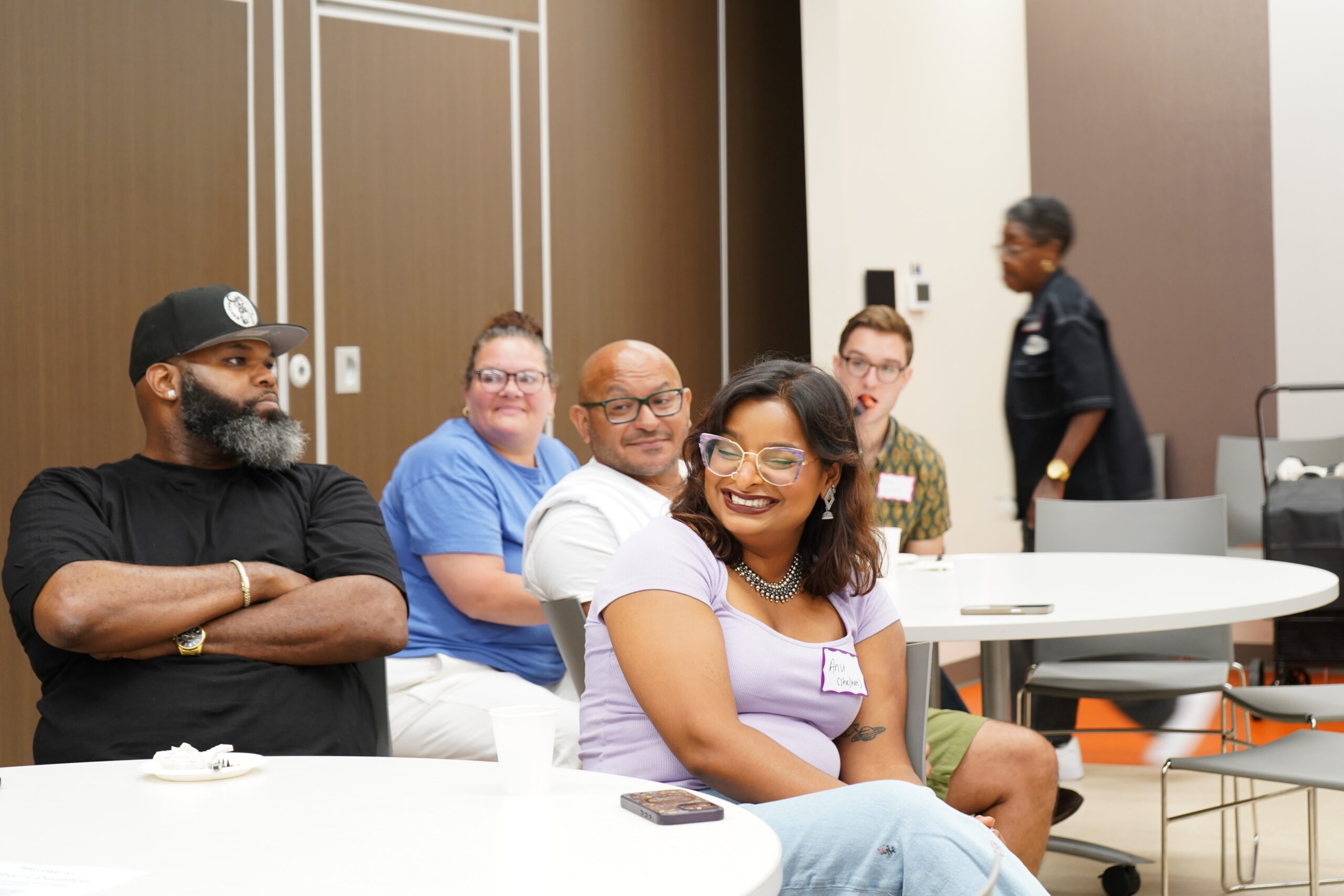 Attendees seated at tables smiling and listening during a MAHRWC training