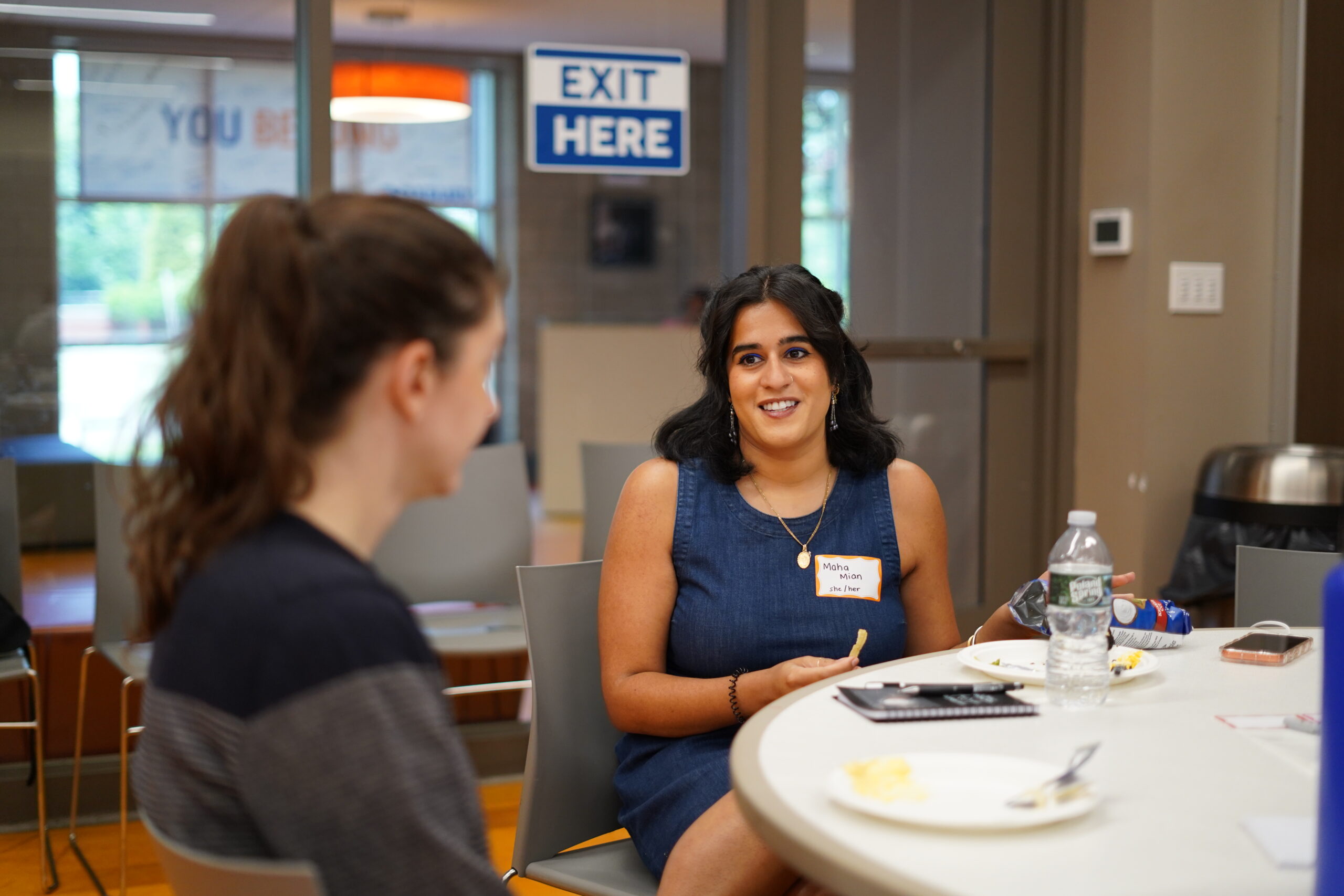 Participant in a name tag smiling during a conversation at a MAHRWC training